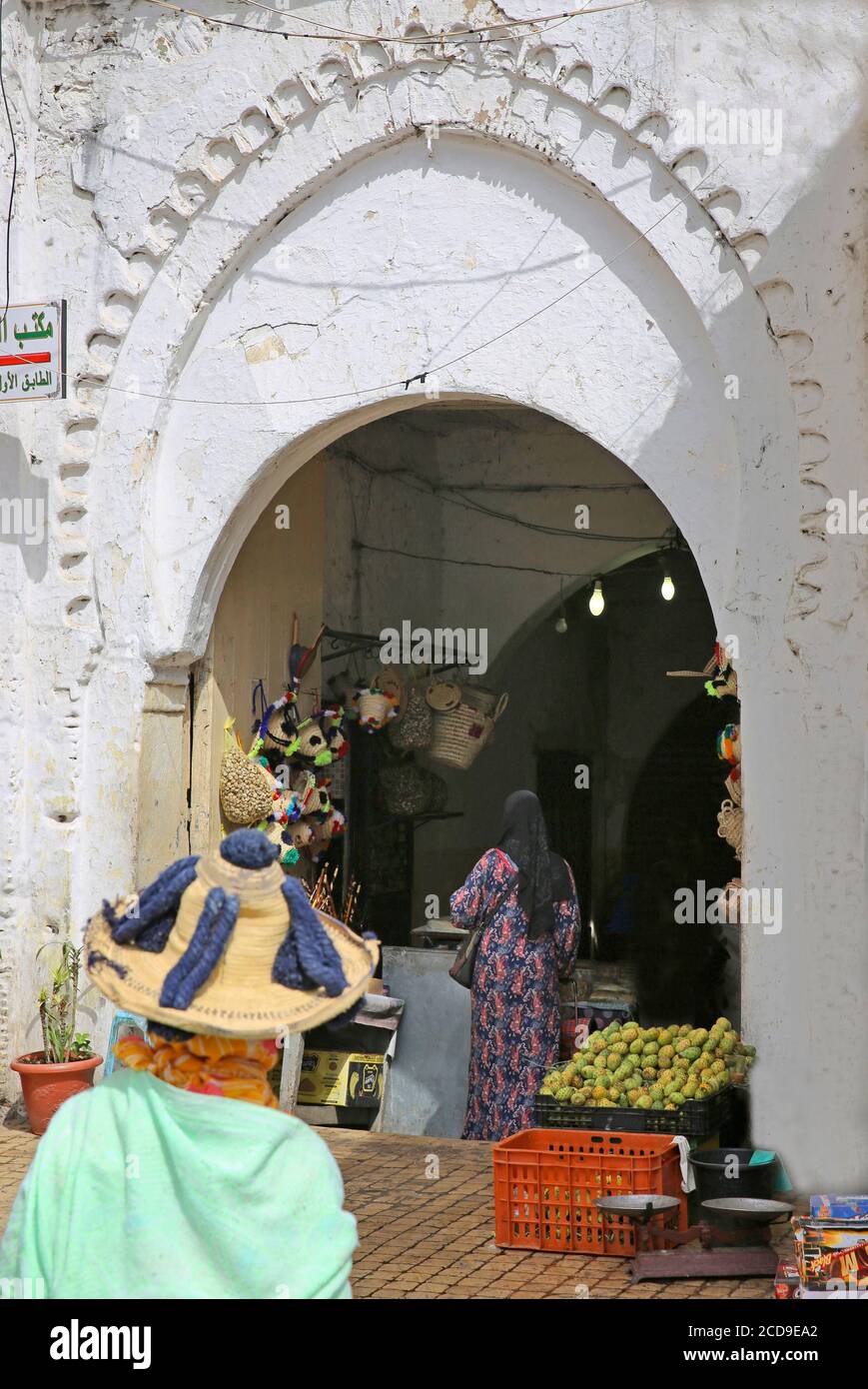 Maroc, région de Tanger Tétouan, Tanger, paysanne avec un chapeau traditionnel devant une porte de souk Banque D'Images