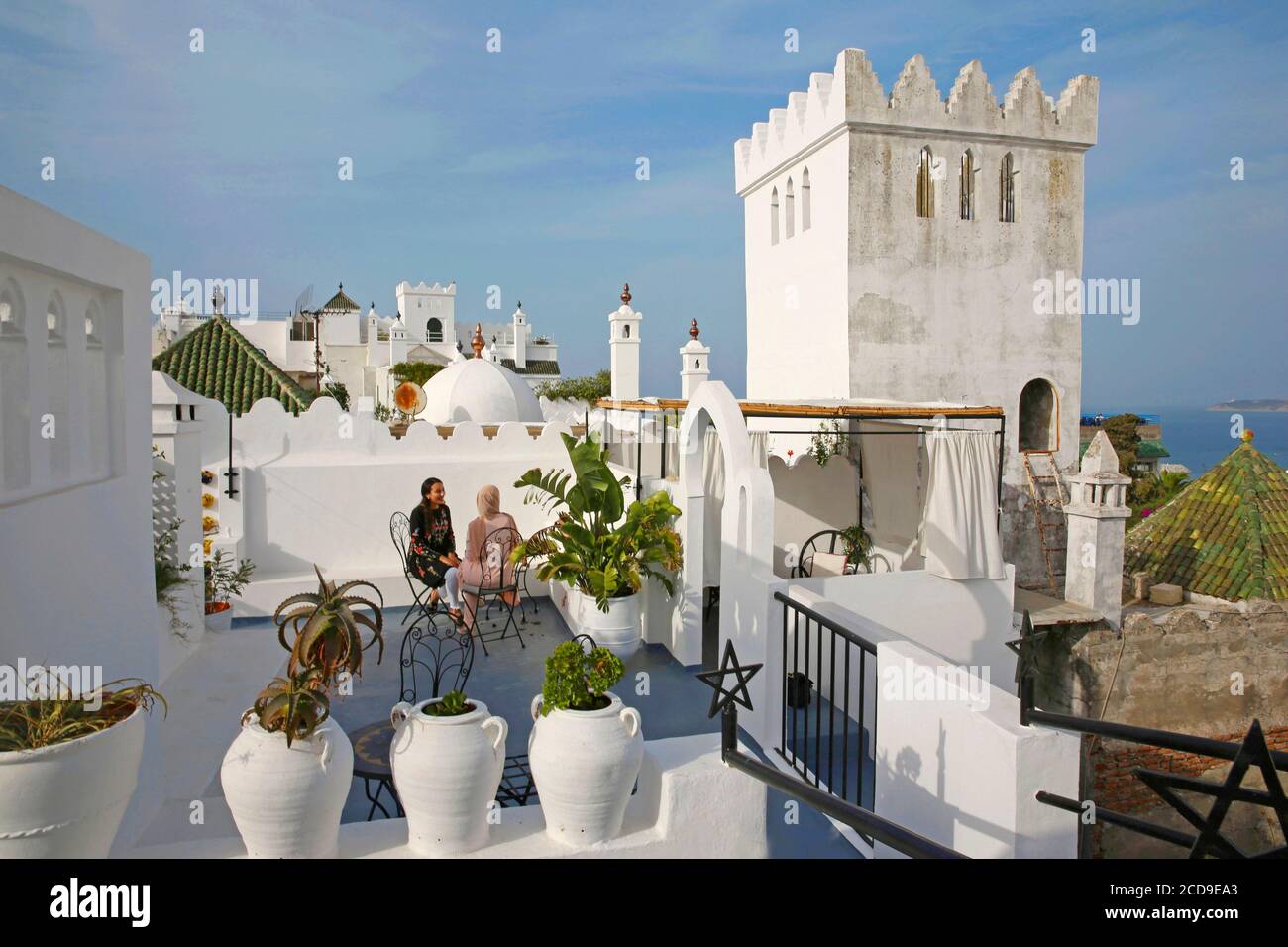 Maroc, région de Tanger Tetouan, Tanger, femmes marocaines sur la terrasse de l'hôtel Abyssinien à Tanger, face à une tour blanche crénelée donnant sur la Méditerranée Banque D'Images