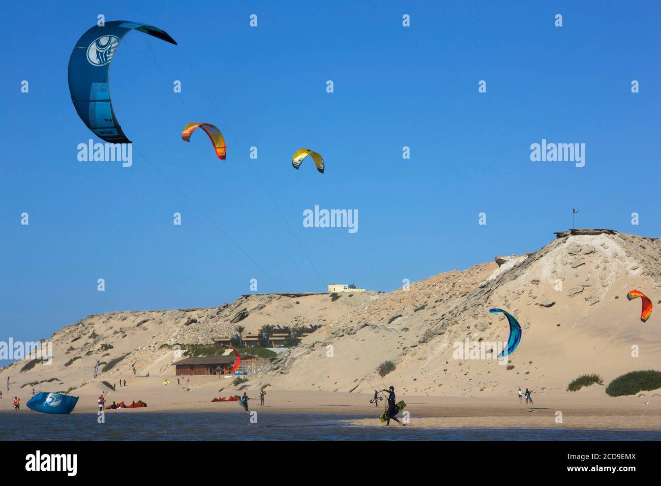 Maroc, Sahara occidental, Dakhla, kitersurfeurs sur la lagune avec dunes de sable en arrière-plan Banque D'Images