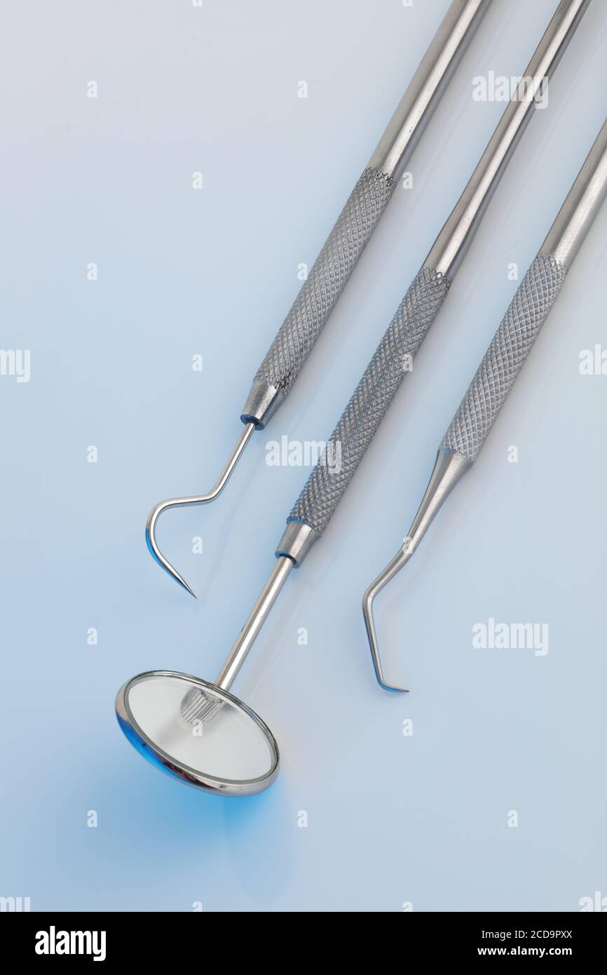Outils dentaires sous une lumière bleue clinique Banque D'Images