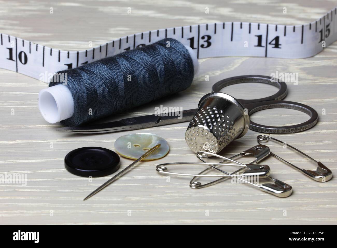 Fournitures et équipement pour coudre sur une surface de travail en bois ruban de coton mesurer ciseaux à aiguilles boutons Banque D'Images