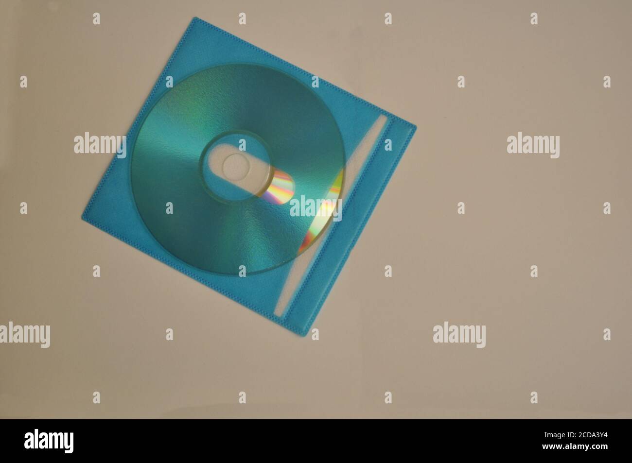 Disque compact pour l'enregistrement de données sur la couverture en tissu non tissé TNT vue de dessus bleue sur fond blanc Banque D'Images