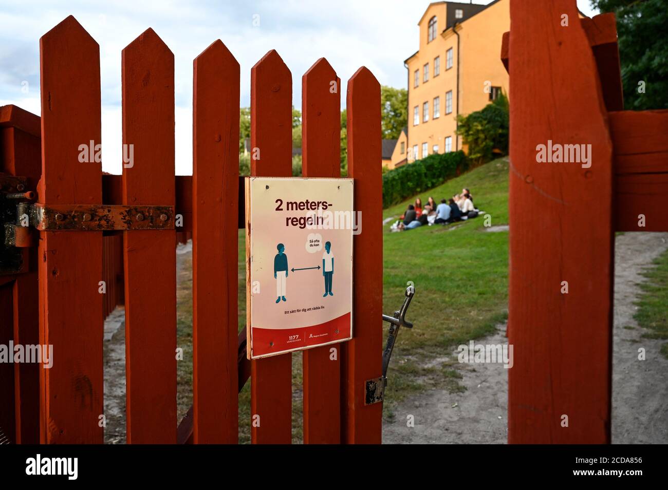 SUÈDE, Stockholm, pandémie de corona, maladie de Covid 19, pas de besoin de fermeture et de masque, mais règles de distance, entrée du parc public avec clôture en peinture rouge suédoise traditionnelle Banque D'Images