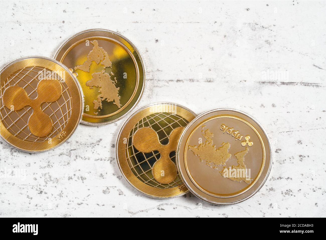 Vue de dessus, groupe d'ondulations dorées - XRP - pièces de monnaie sur panneau de pierre blanche Banque D'Images