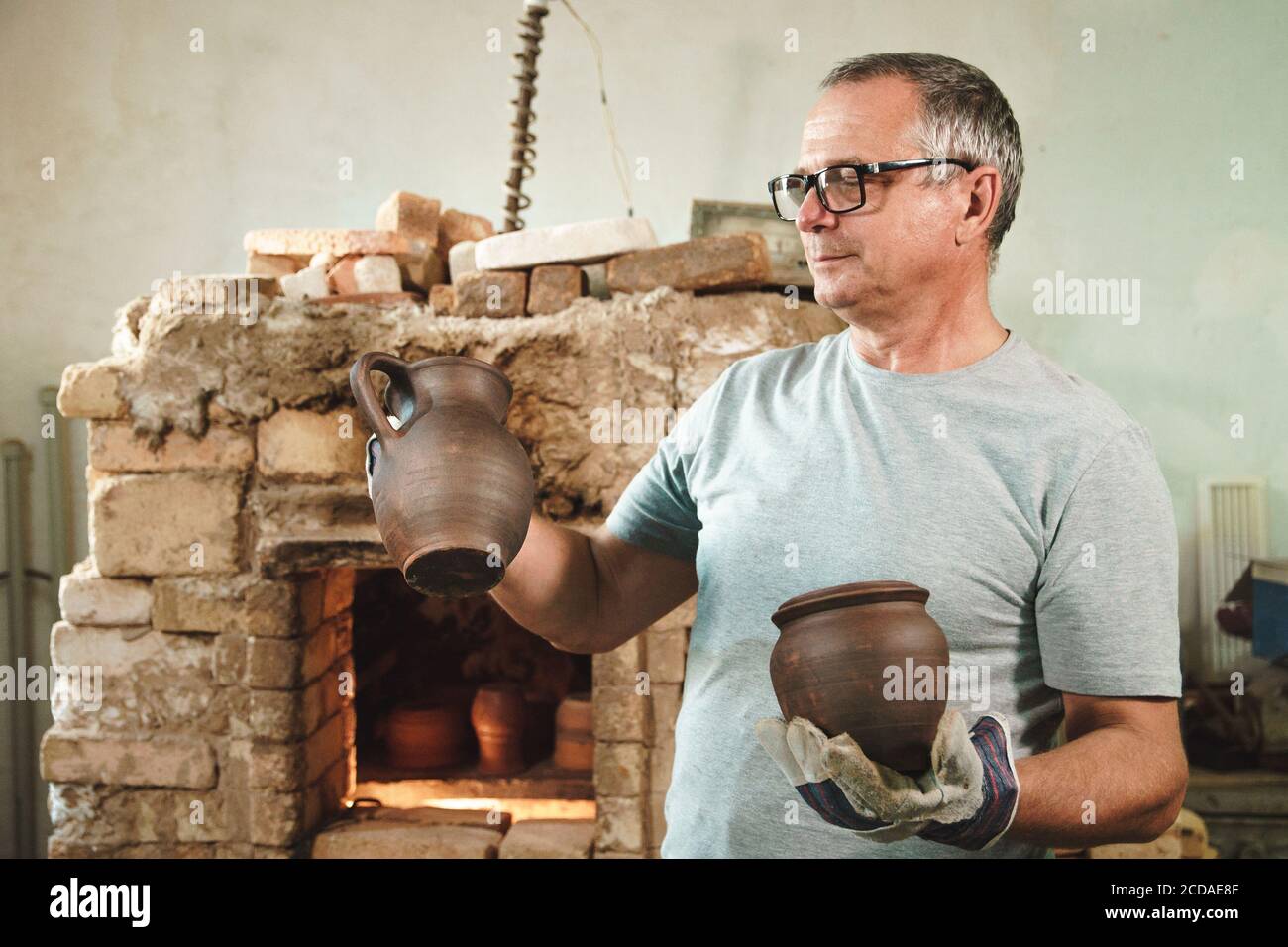 Master potter se tient près du four de poterie et regarde son produit. Banque D'Images
