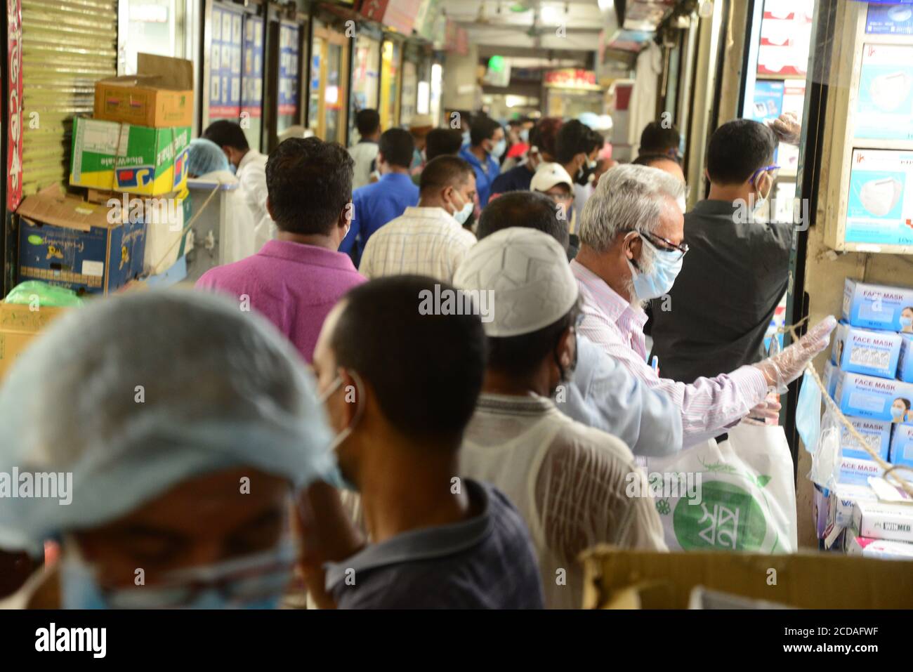 Les gens se rassemblent sur un marché pour acheter des produits de protection comme mesure préventive contre l'épidémie de coronavirus COVID-19 à Dhaka, au Bangladesh, le 3 juin, Banque D'Images