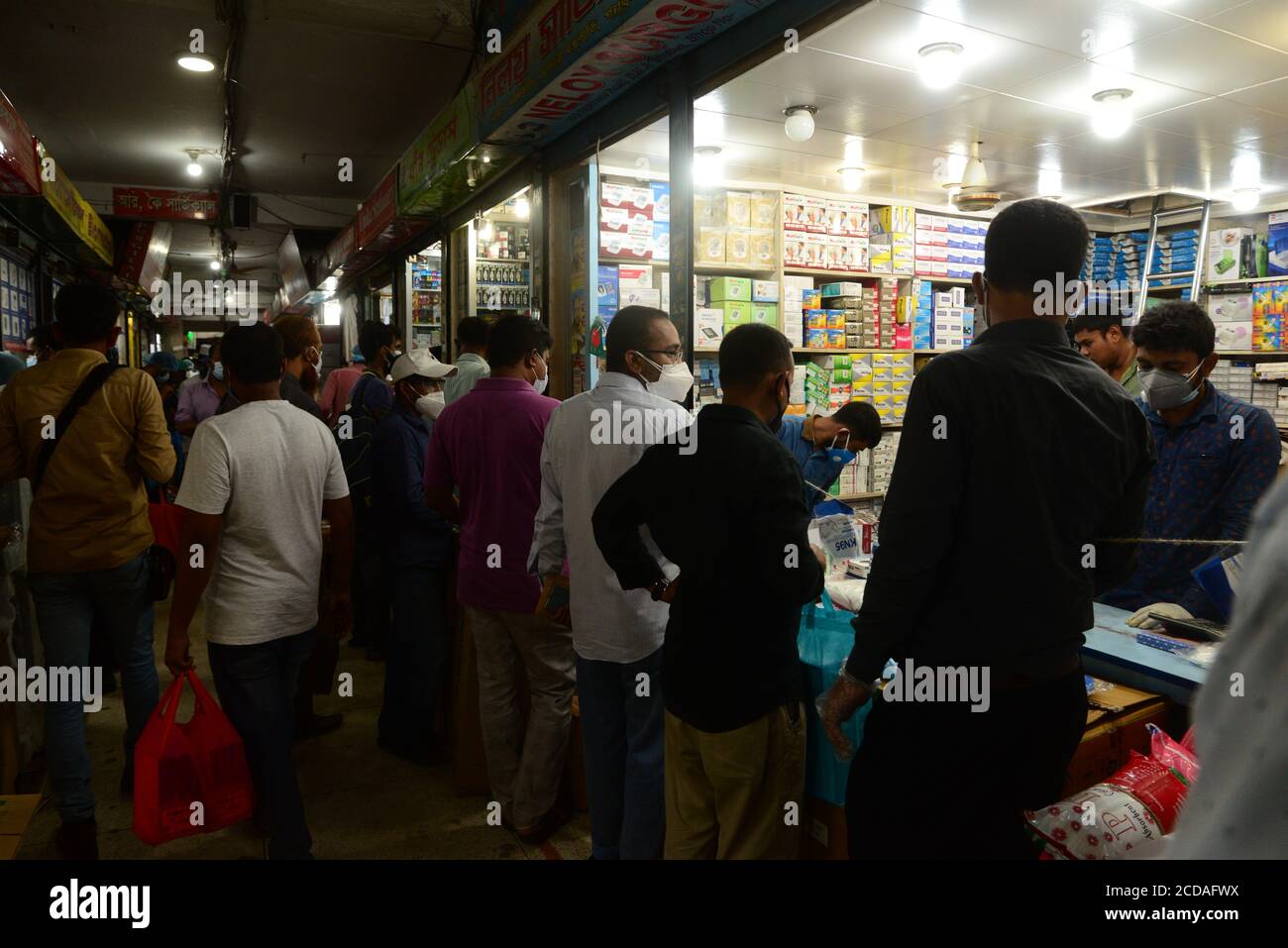 Les gens se rassemblent sur un marché pour acheter des produits de protection comme mesure préventive contre l'épidémie de coronavirus COVID-19 à Dhaka, au Bangladesh, le 3 juin, Banque D'Images