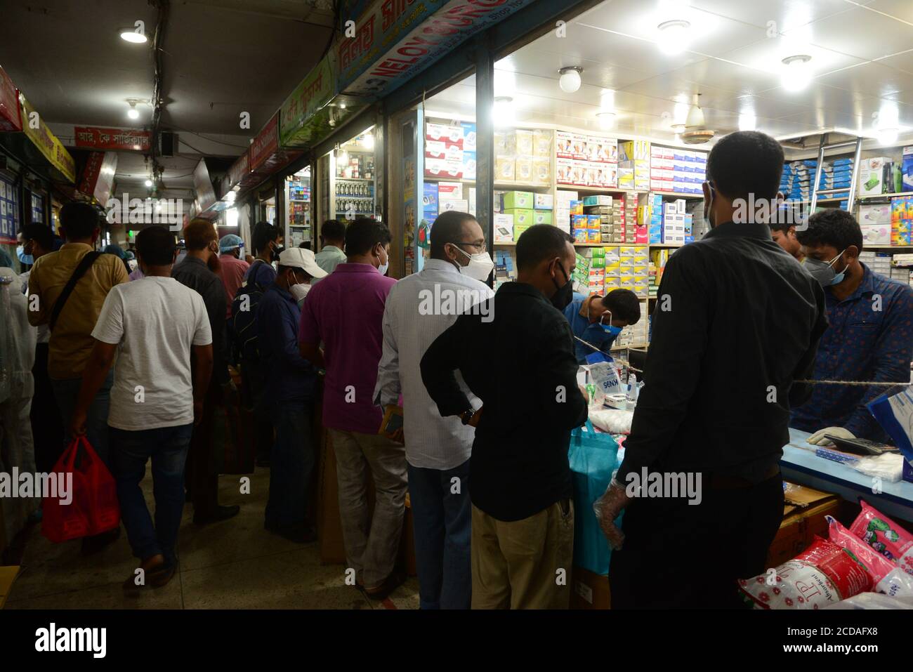 Les gens se rassemblent sur un marché pour acheter des produits de protection comme mesure préventive contre l'épidémie de coronavirus COVID-19 à Dhaka, au Bangladesh, le 3 juin, Banque D'Images