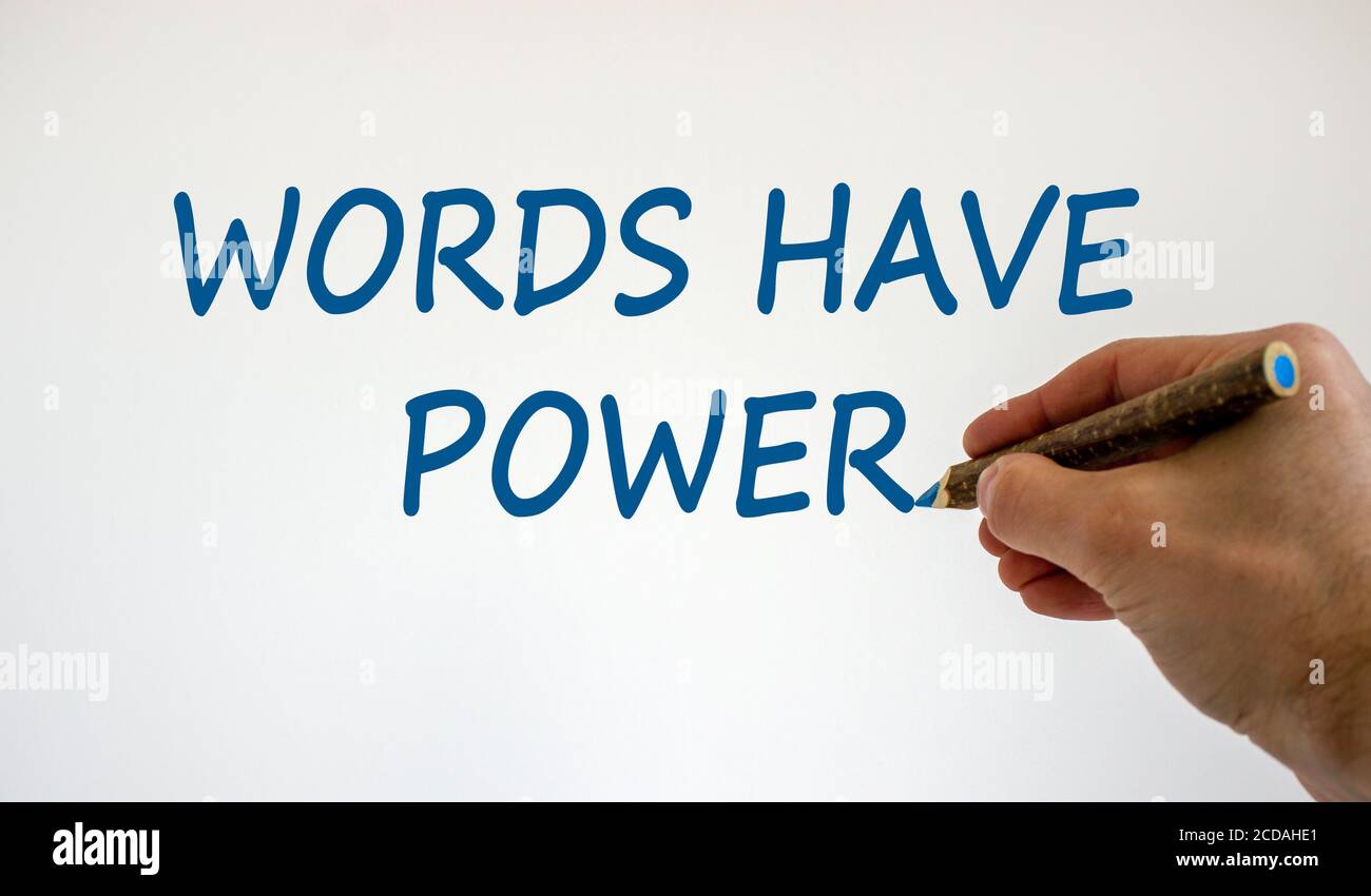 Main avec un crayon bleu écrivant « les mots ont du pouvoir », isolé sur un magnifique fond blanc. Concept. Copier l'espace. Banque D'Images