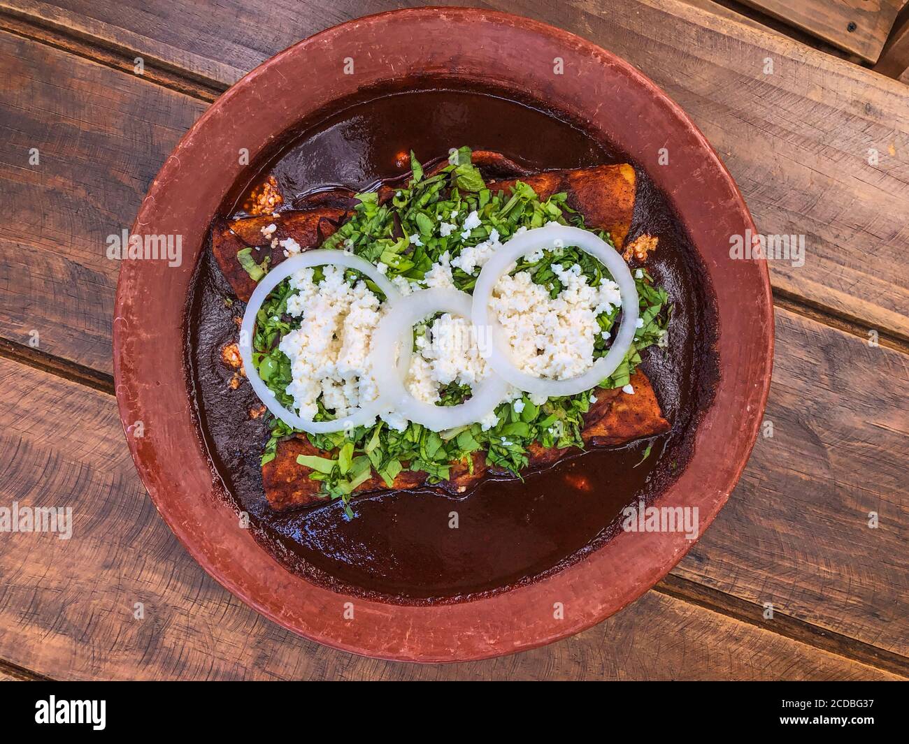 Tacos de poulet rellenos ou tacos de poulet roulés servis avec une sauce mole coloradito. C'est un plat Oaxacan très typique au Mexique. Banque D'Images