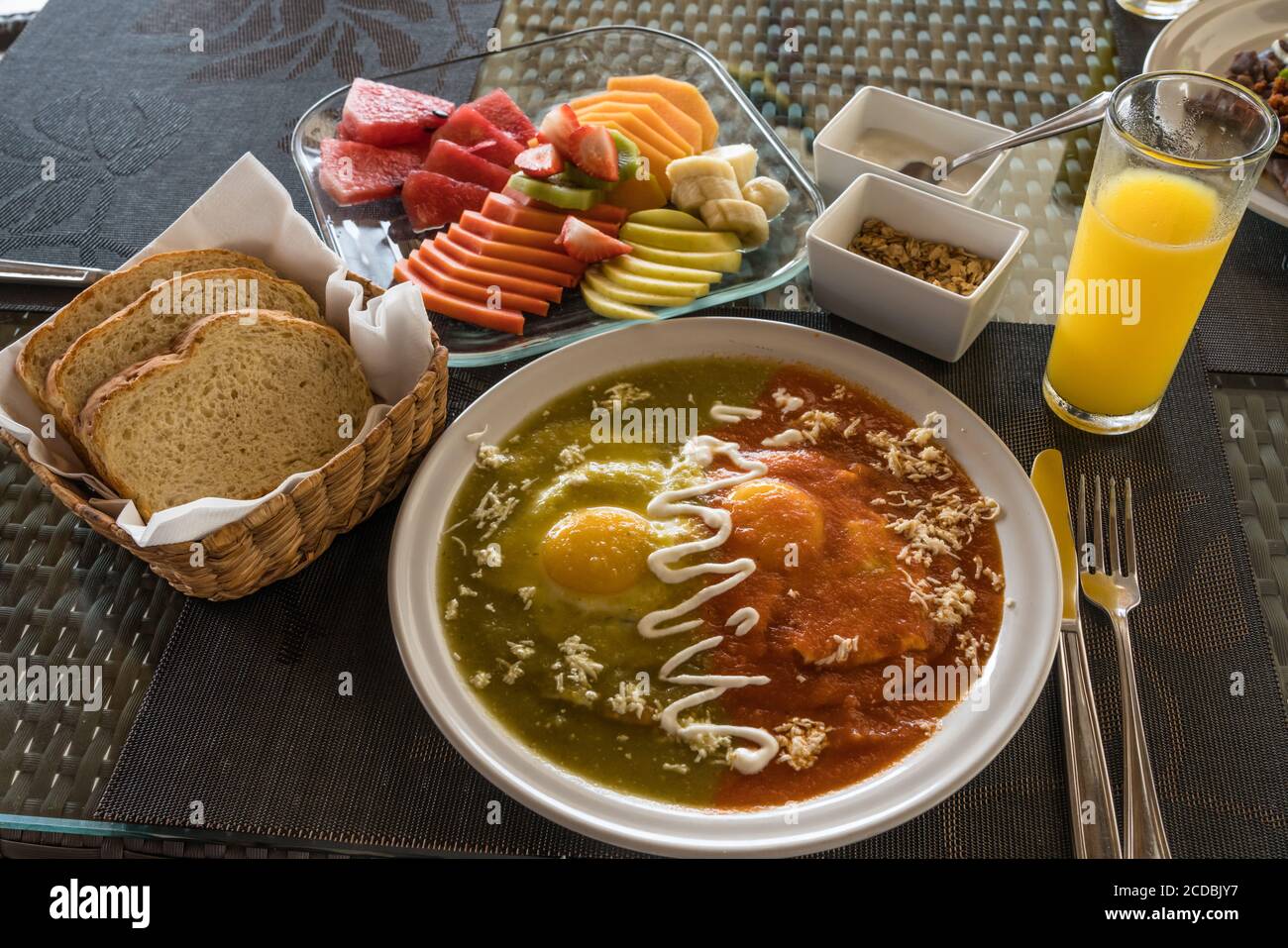 Huevos Divorciados, ou oeufs divorcés, pour le petit déjeuner au Mexique. Un œuf frit est dans la sauce au Chili rouge et un dans la salsa au Chili vert. Banque D'Images