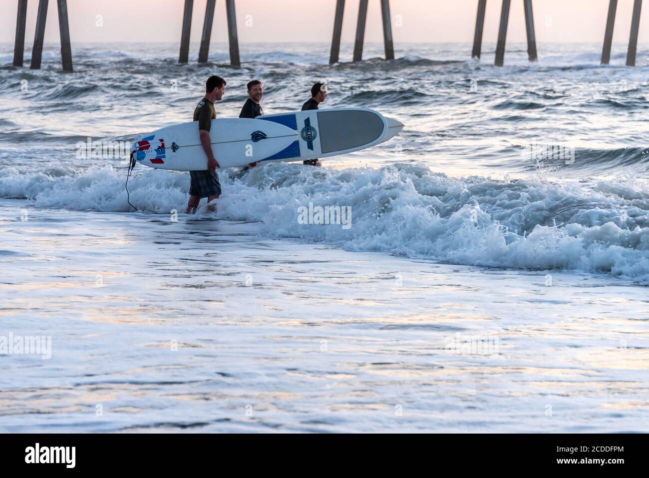 Les surfeurs de Jacksonville Beach, Floride, se dirigent vers une séance de surf au lever du soleil. (ÉTATS-UNIS) Banque D'Images