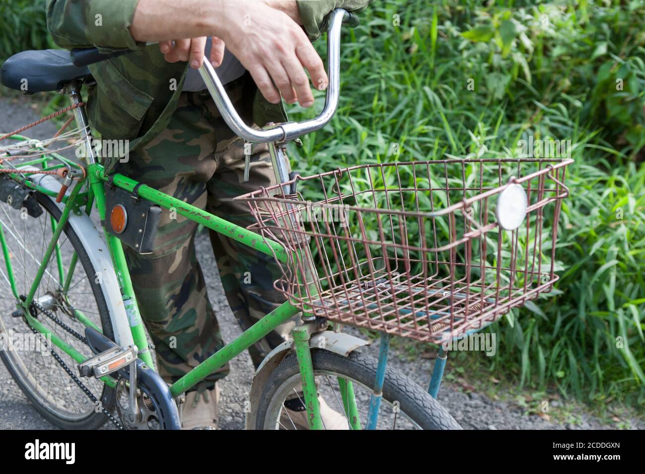 Un cycliste debout près d'un vieux vélo avec un rack en métal, tir en plein air Banque D'Images