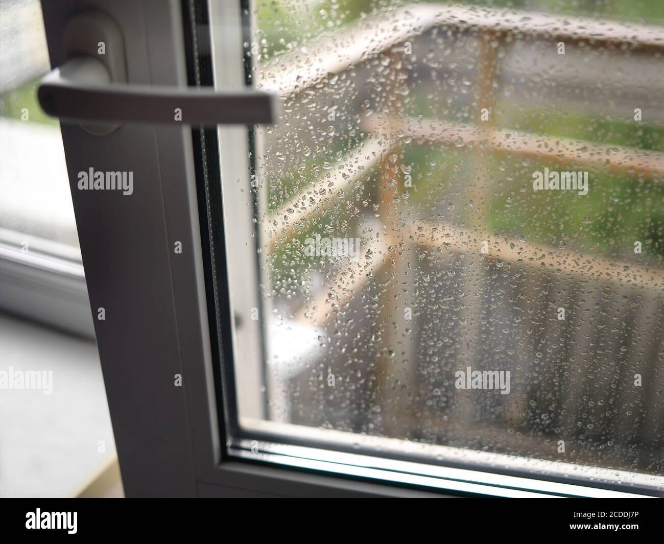 Gouttes de pluie sur la porte transparente du balcon, DOF peu profond Banque D'Images