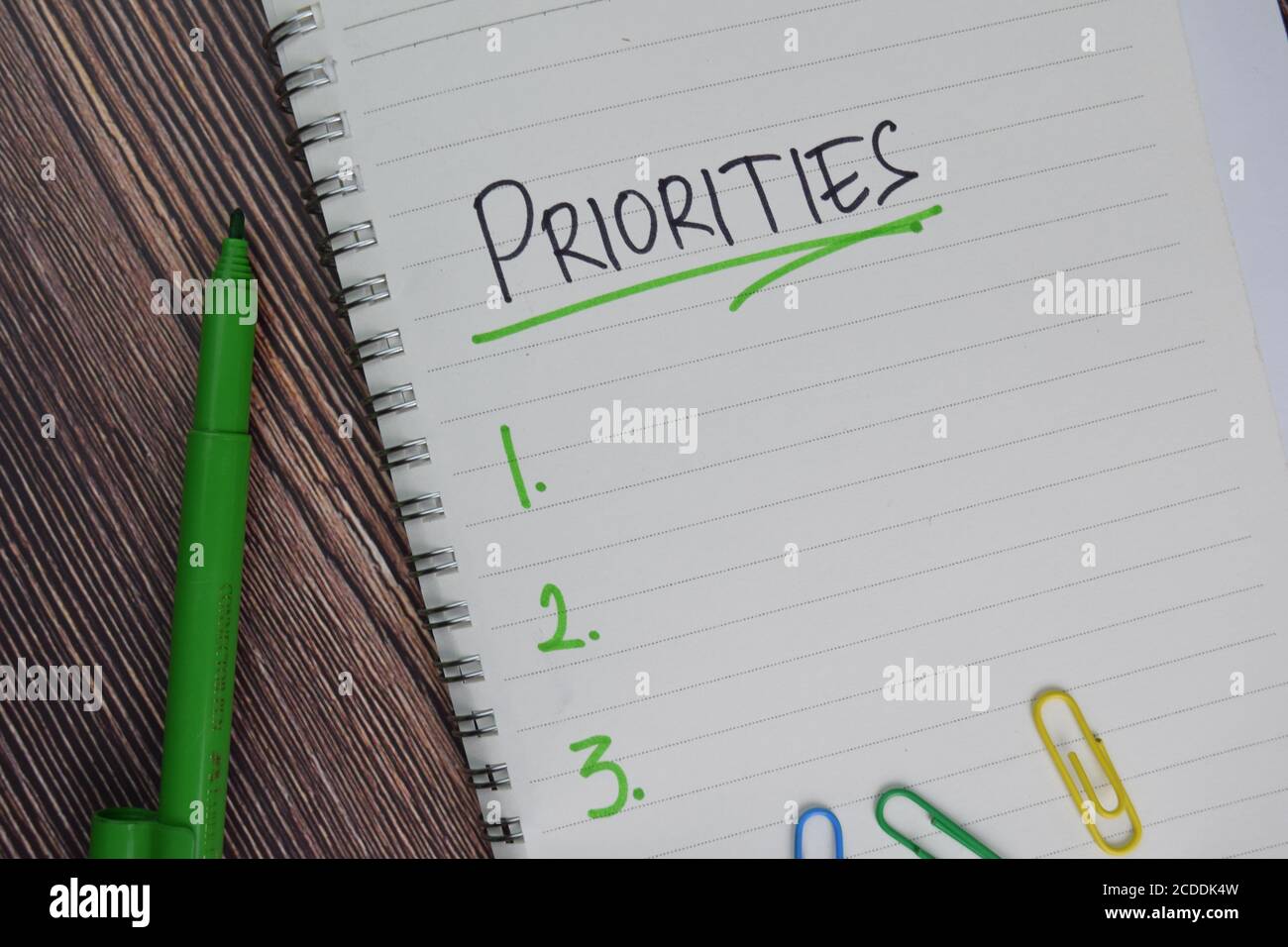 Les priorités sont à noter sur un pense-bête. Supporté par une table en bois isolée de services supplémentaires. Banque D'Images
