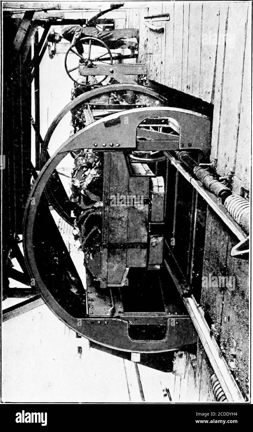 . Cyclopedia de manutention; un livre de référence couvrant les définitions, les descriptions, les illustrations et les méthodes d'utilisation des machines de manutention utilisées dans l'industrie . arrangé de manière à ce que la voie horizontale recevant les voitures soit alignée avec le plancher de la bâche.dans le type de gravité, Fig. 2, après qu'une voiture a été conduite sur le vidage, le frein à main qui maintient le vidage en positionest relâché et le poids de la voiture et de sa charge est suffisamment lourd pour provoquer la rotation. Un contrepoids placé au fond de la machine provoque le retour de la décharge à sa position normale après la vidange de la voiture. Le commutateur rotatif à commande électrique Banque D'Images