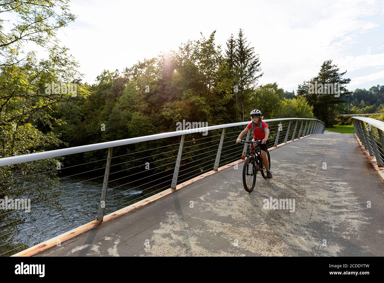 Un jeune garçon fait du vélo sur une passerelle Banque D'Images
