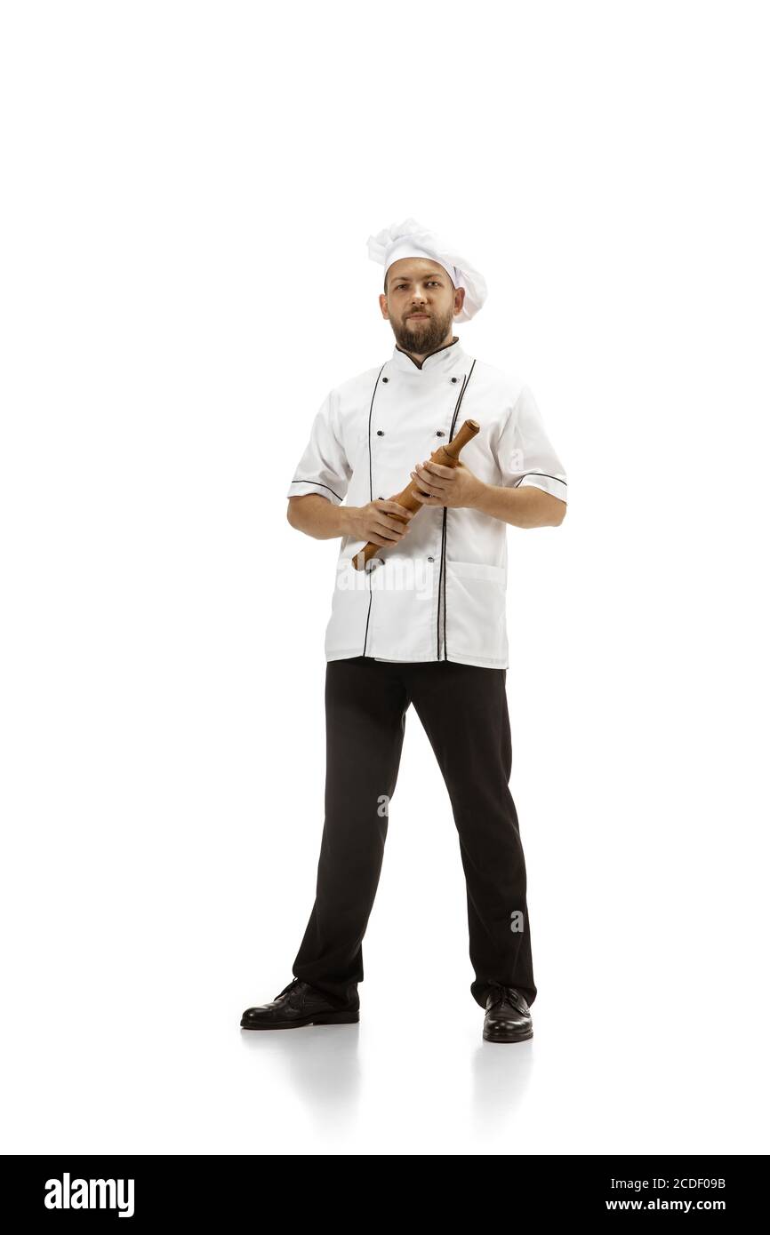 Cuisinière, chef, boulanger en uniforme isolé sur fond blanc studio, gastronomique. Jeune homme, portrait de cuisinière de restaurant. Affaires, la porte, l'occupation professionnelle, le concept d'émotions. CopySpace pour publicité. Banque D'Images