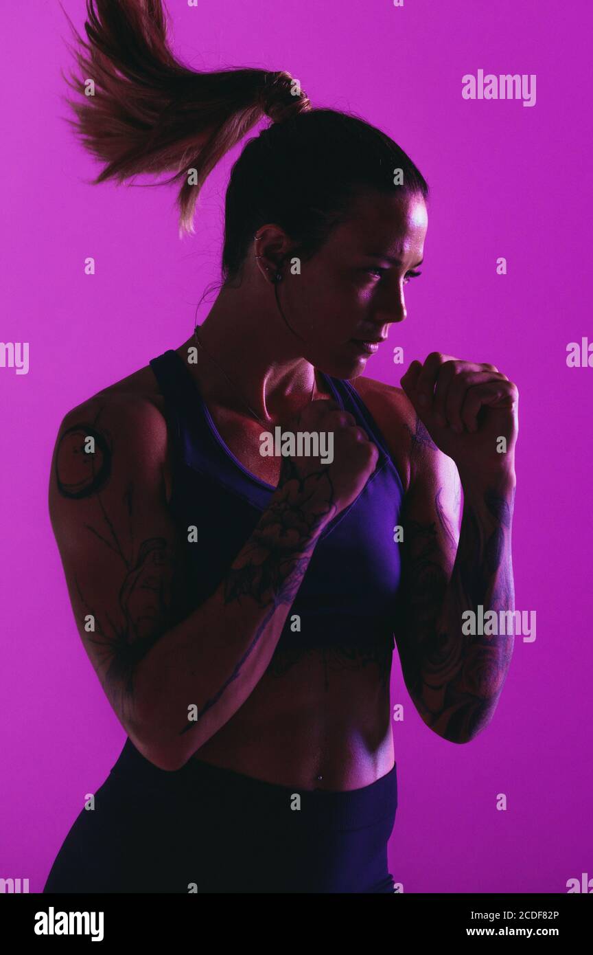 Portrait de boxeur féminin debout avec des poings fermés. Femme ciblée athlète en boxe. Banque D'Images