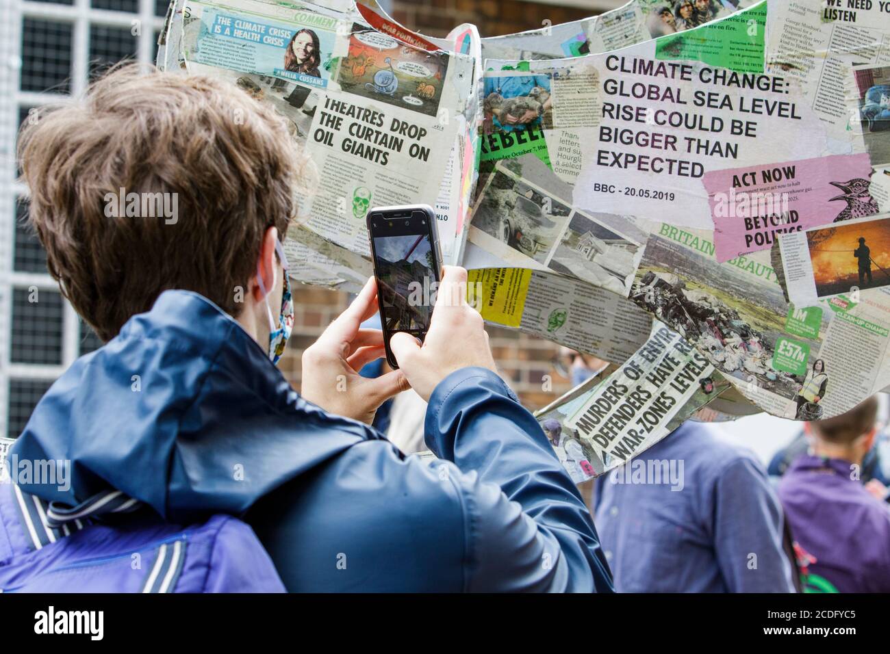 Bristol, Royaume-Uni. 28 août 2020. Un homme est photographié alors qu'il prend une photo des œuvres d'art « éléphant dans une pièce » des activistes climatiques de la rébellion de l'extinction sur un barrage routier de la route menant au pont de Princes Street Bridge dans le centre de Bristol. Les quatre jours de protestation de la rébellion ont lieu pour souligner les militants qui affirment que le gouvernement britannique ignore tous les avertissements concernant la crise climatique et écologique. Credit: Lynchpics/Alamy Live News Banque D'Images