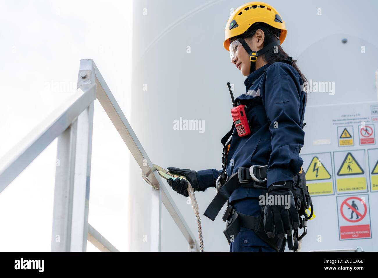 Femme asiatique un ingénieur d'inspection portant un harnais de sécurité et une ligne de sécurité préparation du travail et vérification de la progression d'une éolienne avec sécurité dans les parcs éoliens Banque D'Images