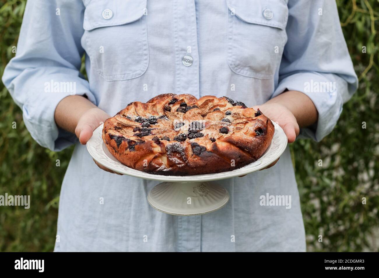 Une femme tient des mains de tarte aux pommes maison avec des bleuets Banque D'Images