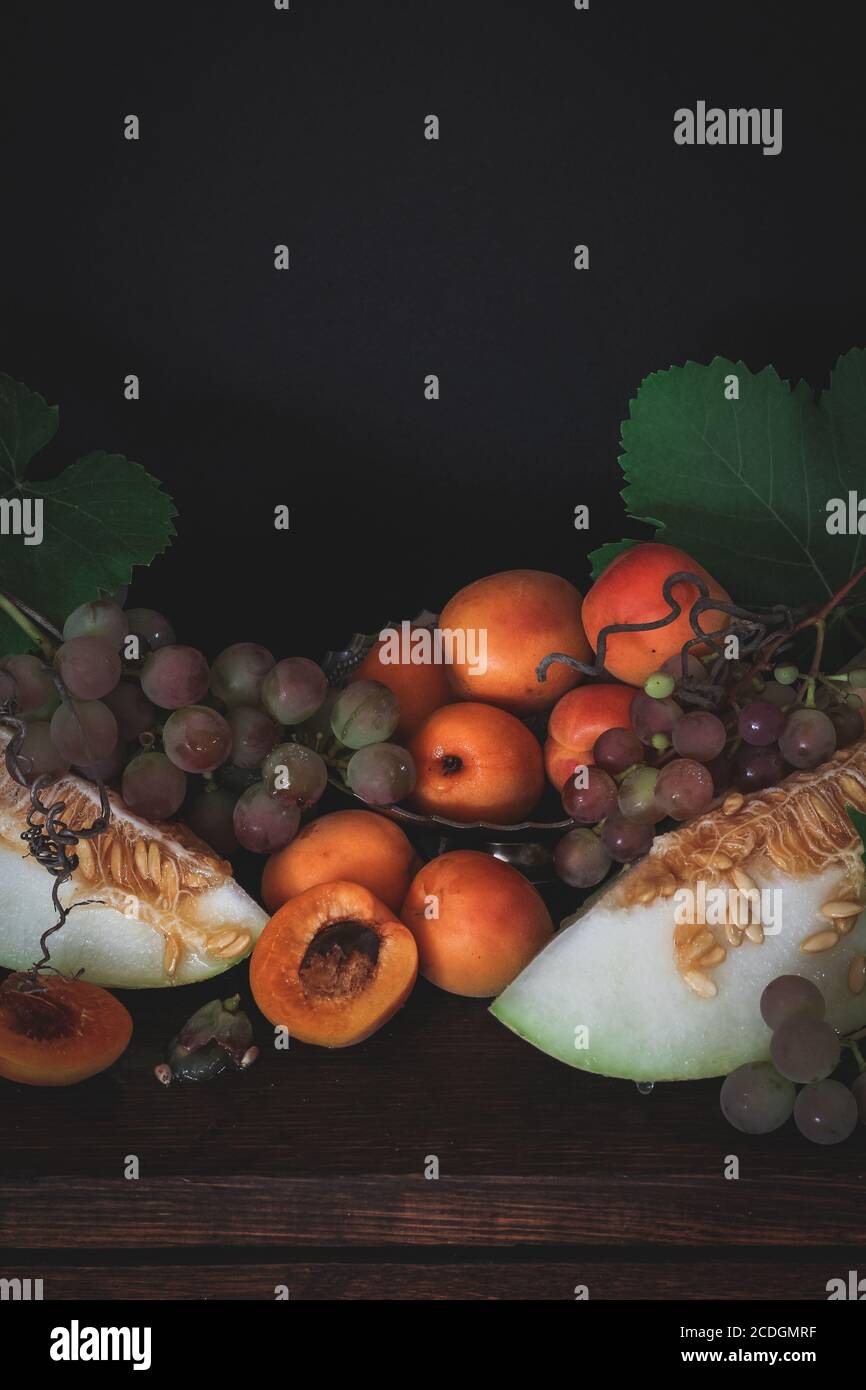 L'automne encore la vie avec les abricots, les raisins et le melon, humeur sombre Banque D'Images
