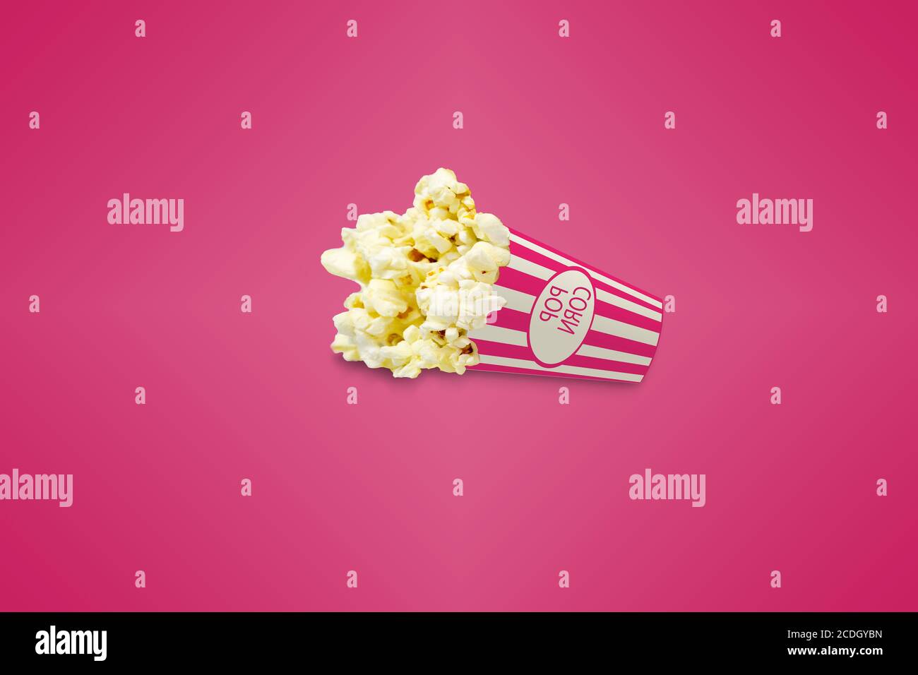 pop-corn avec ombre sur fond rose : boîte de pop-corn : concept cinéma Banque D'Images