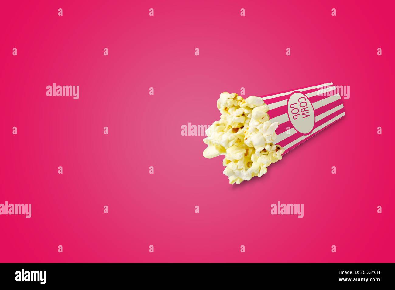 pop-corn avec ombre sur fond rose : boîte de pop-corn : concept cinéma Banque D'Images