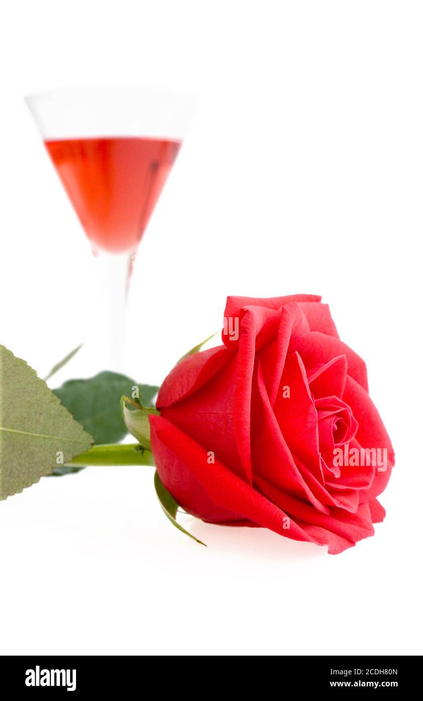 Red Rose doux et d'alcool dans un verre Banque D'Images