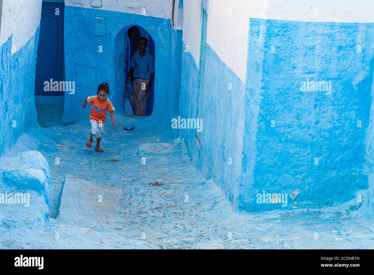 Une petite fille qui court dans les rues de Chefchaouen, au Maroc Banque D'Images