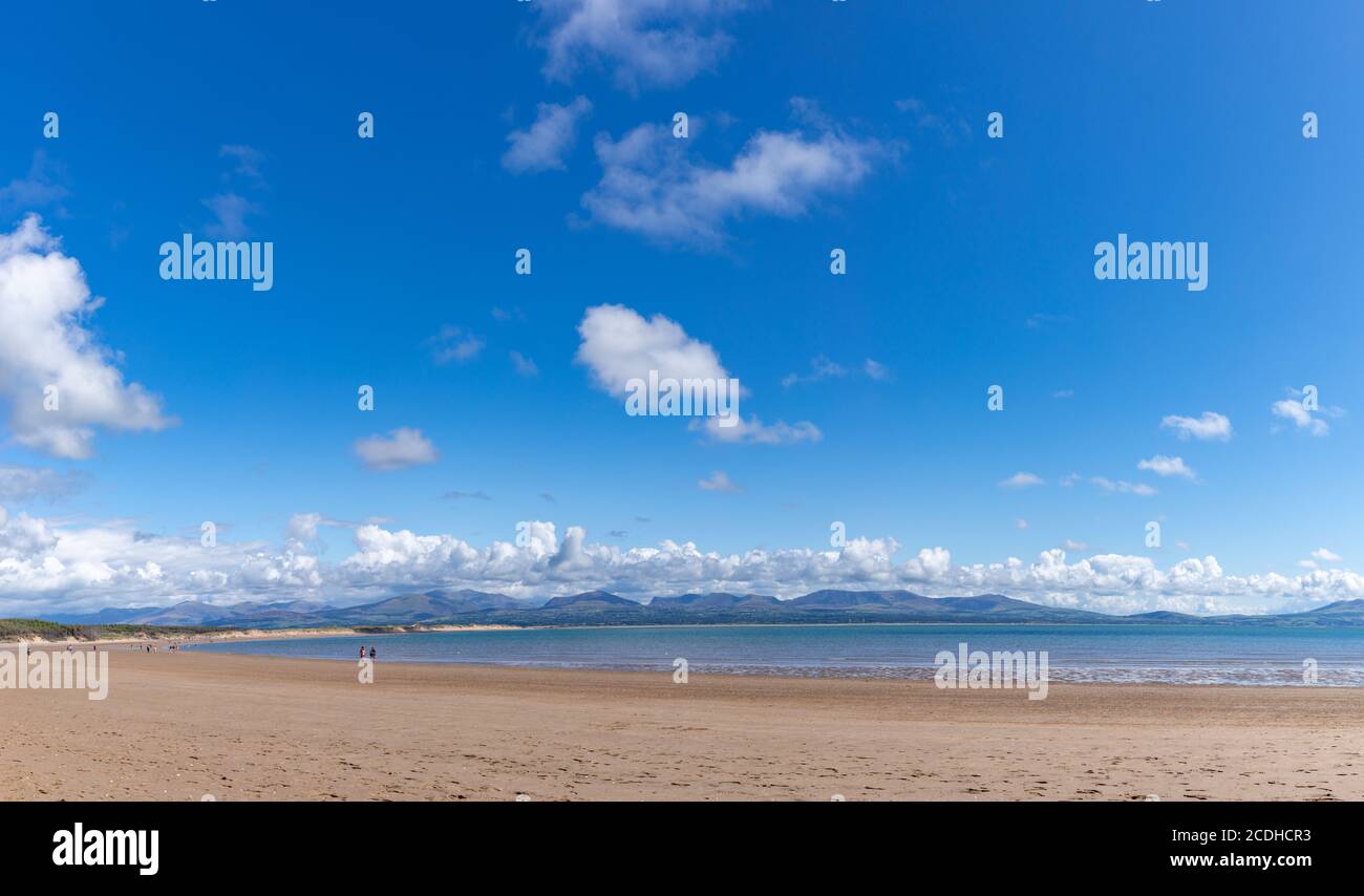 Vue sur la plage de Newborough, en toile de fond sur les montagnes de Snowdonia, vue depuis le sentier côtier de l'île d'Anglesey au pays de Galles, au Royaume-Uni. Banque D'Images