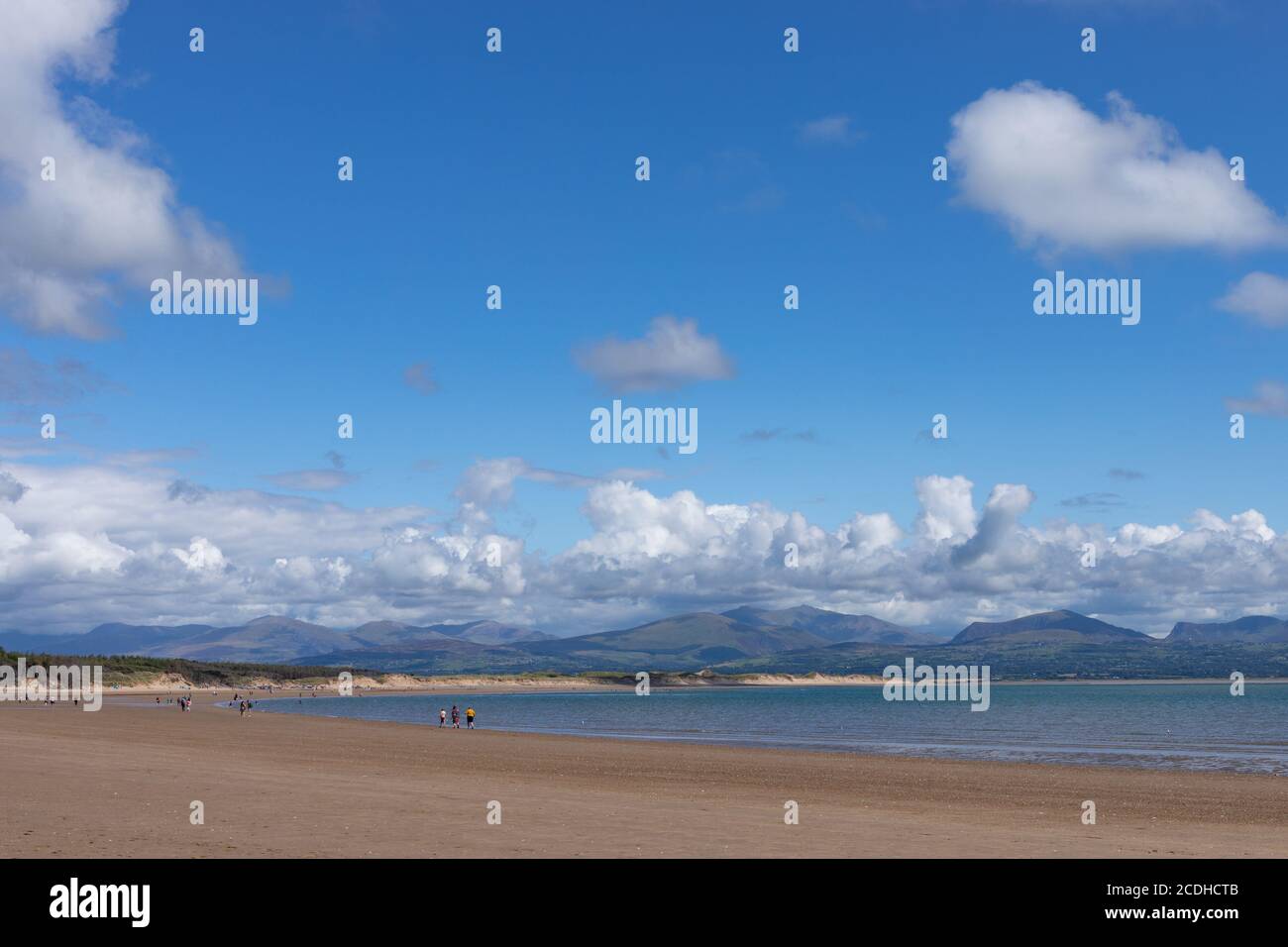 Vue sur la plage de Newborough, en toile de fond sur les montagnes de Snowdonia, vue depuis le sentier côtier de l'île d'Anglesey au pays de Galles, au Royaume-Uni. Banque D'Images