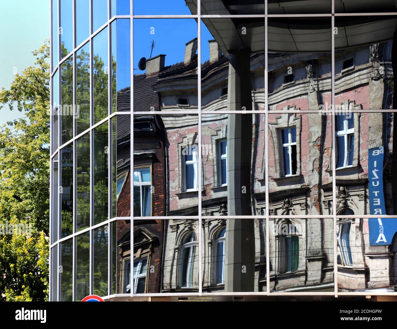 Cracovie. Cracovie. Pologne les anciens bâtiments en bâtiment se reflètent dans la façade en verre du nouveau bâtiment de bureau. Banque D'Images