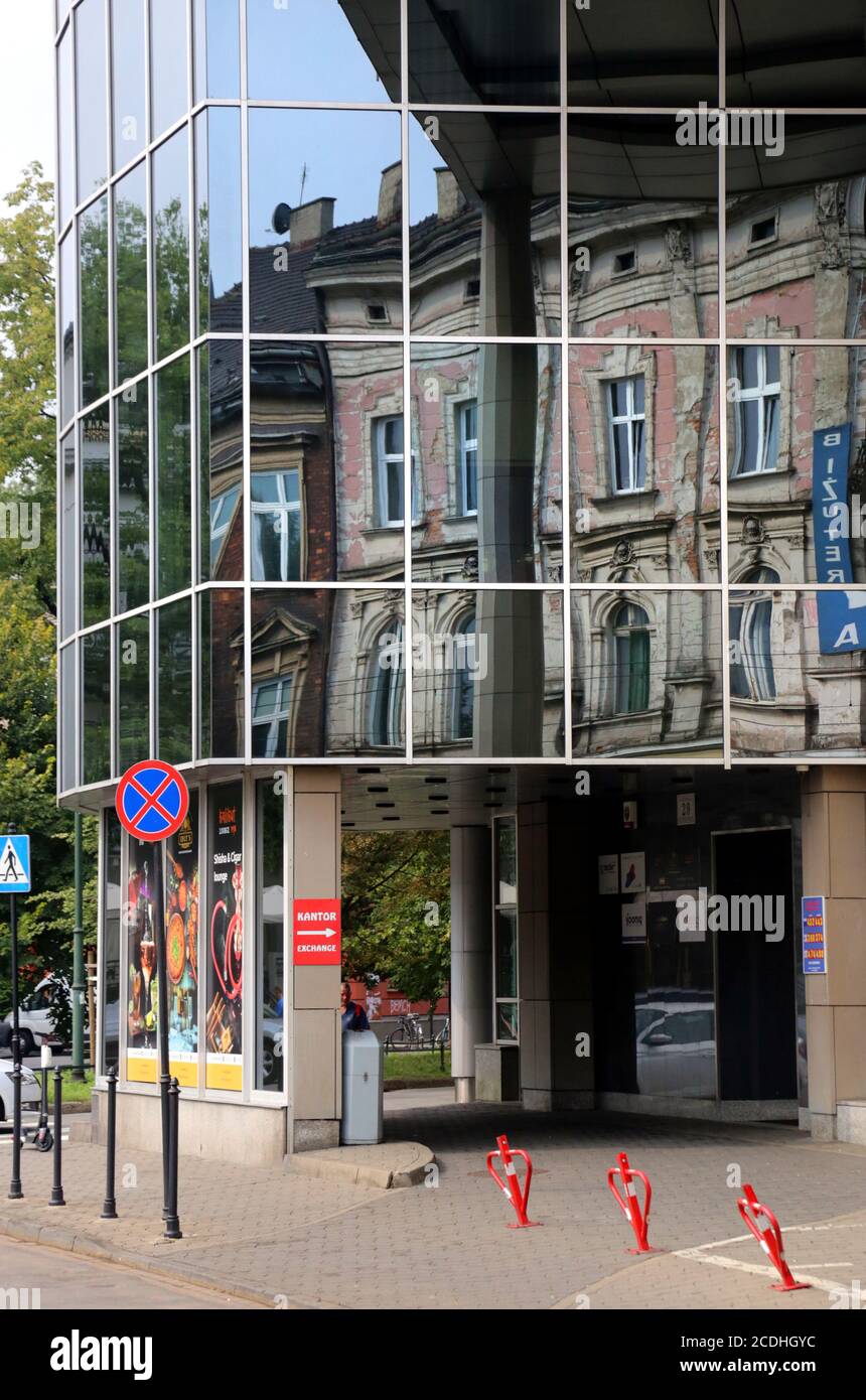 Cracovie. Cracovie. Pologne les anciens bâtiments en bâtiment se reflètent dans la façade en verre du nouveau bâtiment de bureau. Banque D'Images