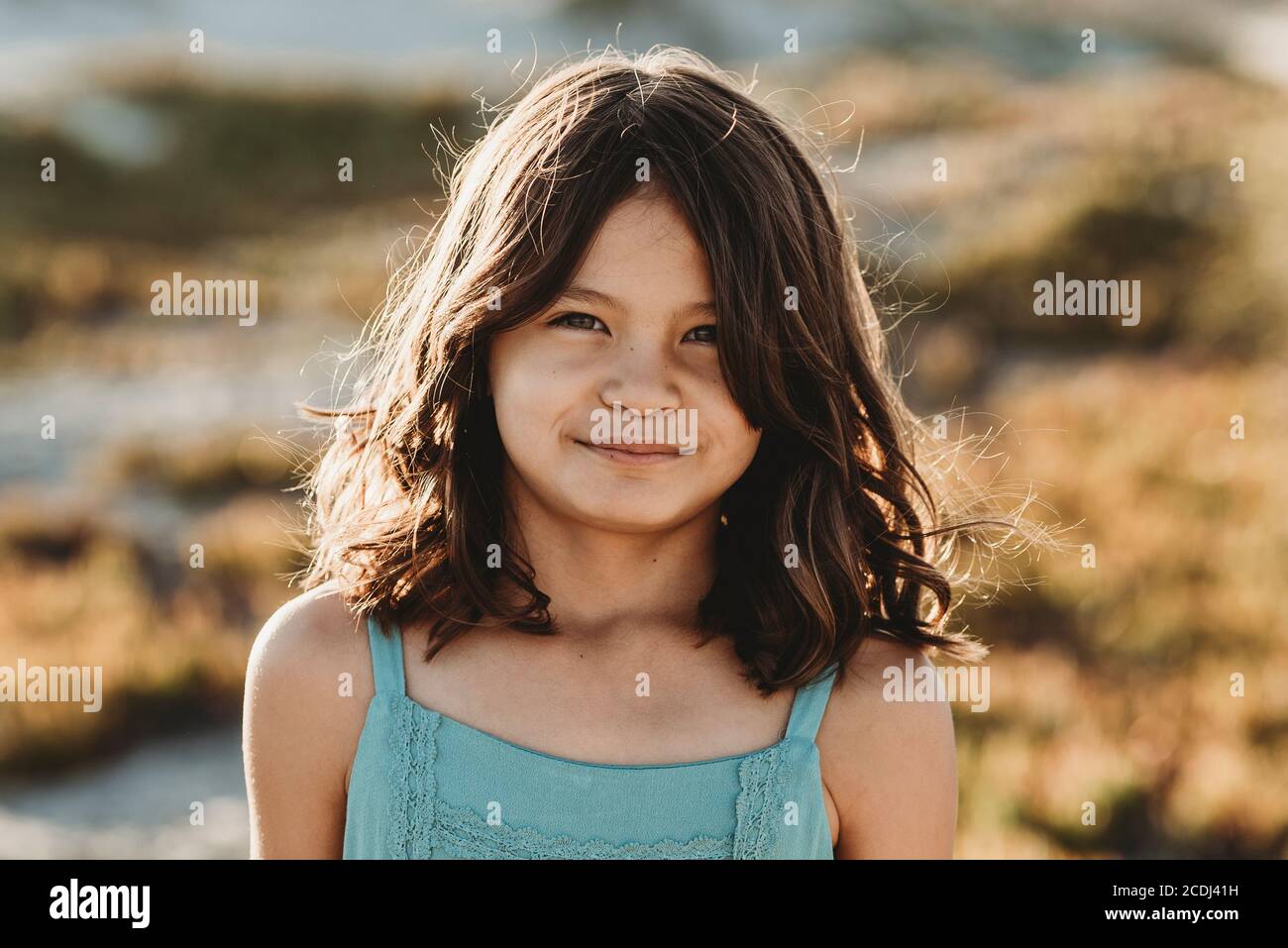 Jeune fille avec les yeux bruns et les cheveux foncés épais portant haut du réservoir bleu Banque D'Images