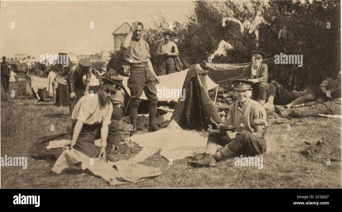 . Voyage janvier 1915 . -  j^C Side of War -le prix convoité pour l'armée et la marine allemandes. (C) International icws bervice SOLDATS ANGLAIS À LA MAISON DANS LE CAMP Soldiering a son côté intérieur, et cette scène à l'extérieur d'un village belge est typique des jours de travail de lavage, de séchage et de brossage dans le camp qu'il sera observé, porte une étiquette d'identification en métal le soldat assis. 28 Banque D'Images