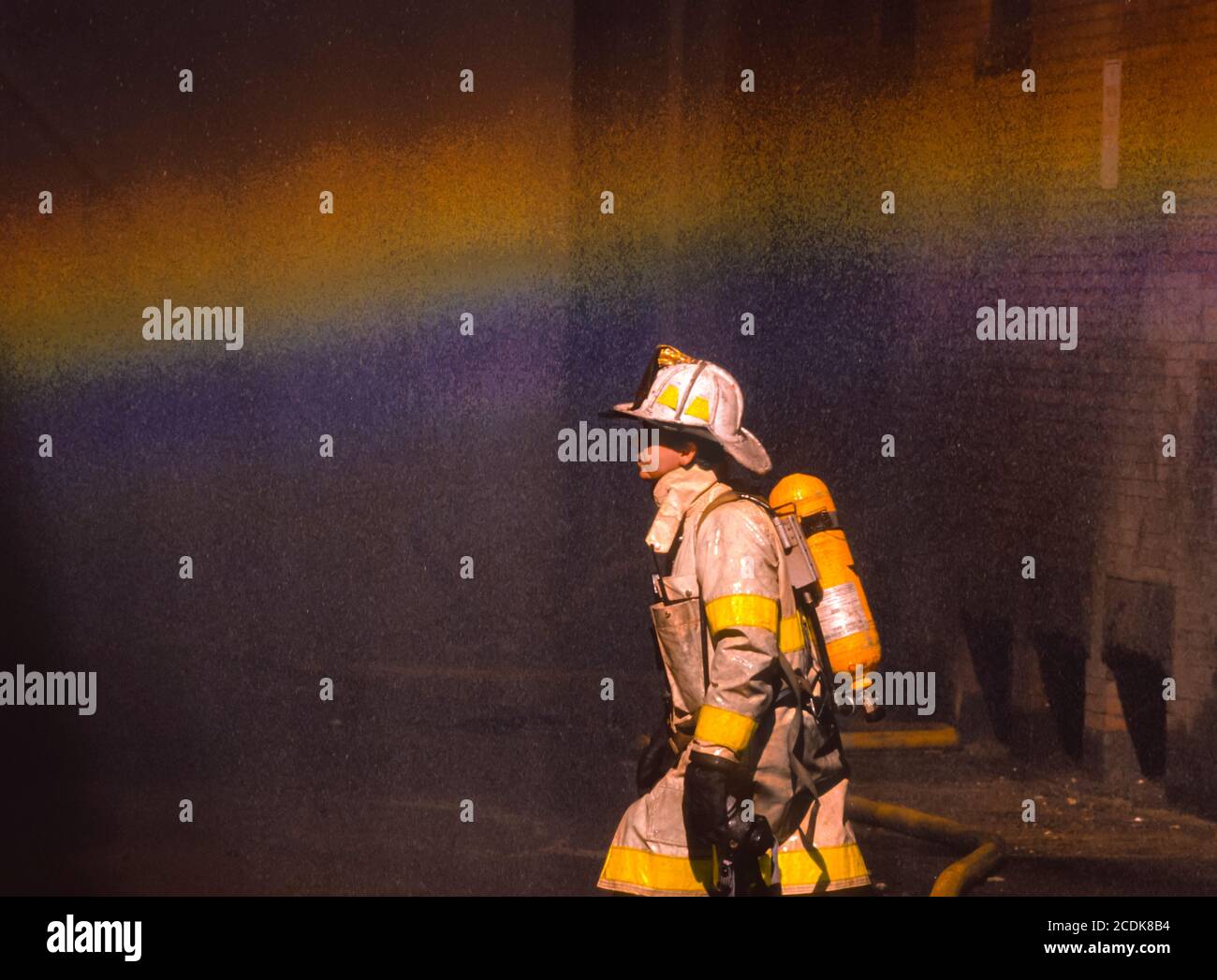 BOSTON, MASSACHUSETTS, États-Unis - pompier et arc-en-ciel dans la brume d'eau, pendant l'incendie de bâtiment. Banque D'Images