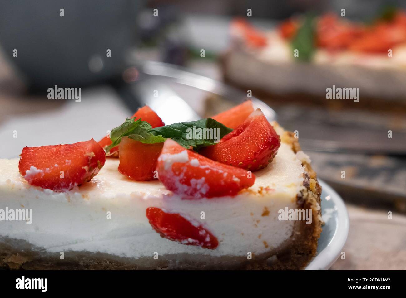 Tranche de cheesecake avec fraises et menthe. Mise au point sélective, gros plan Banque D'Images