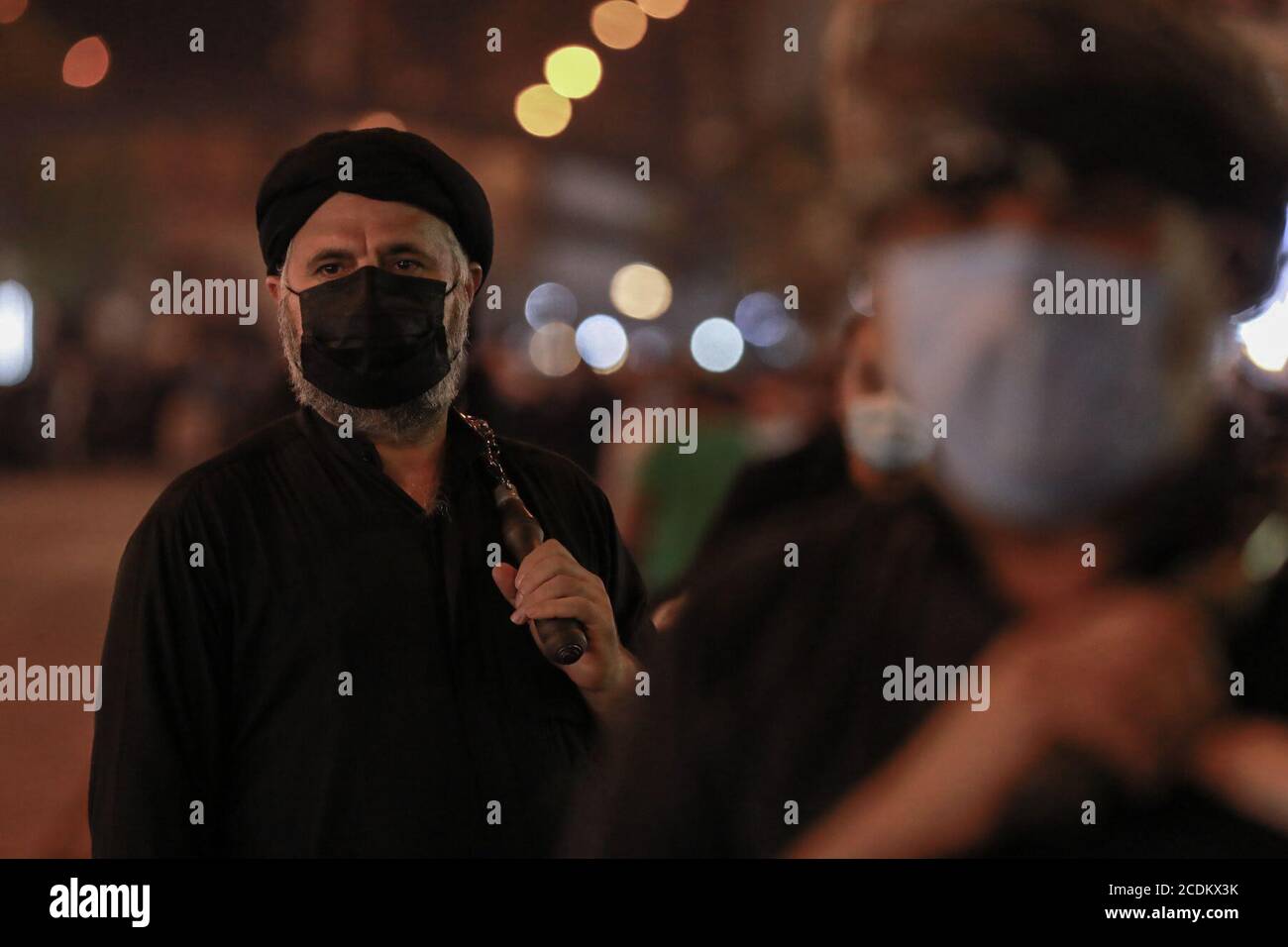 Bagdad, Irak. 28 août 2020. Un homme musulman chiite, portant un masque facial, se flagella avec des chaînes métalliques lors d'une cérémonie rituelle à la veille d'Ashura, devant la mosquée Al-Kadhimiya, le sanctuaire du septième Imam chiite Musa ibn Ja·far al-Kazim. Ashura est un grand jour Saint dans l'Islam chiite qui marque le jour où Husayn ibn Ali, le petit-fils du prophète islamique Muhammad, a été martyrisé dans la bataille de Karbala en 680. Credit: Ameer Al Mohmedaw/dpa/Alamy Live News Banque D'Images