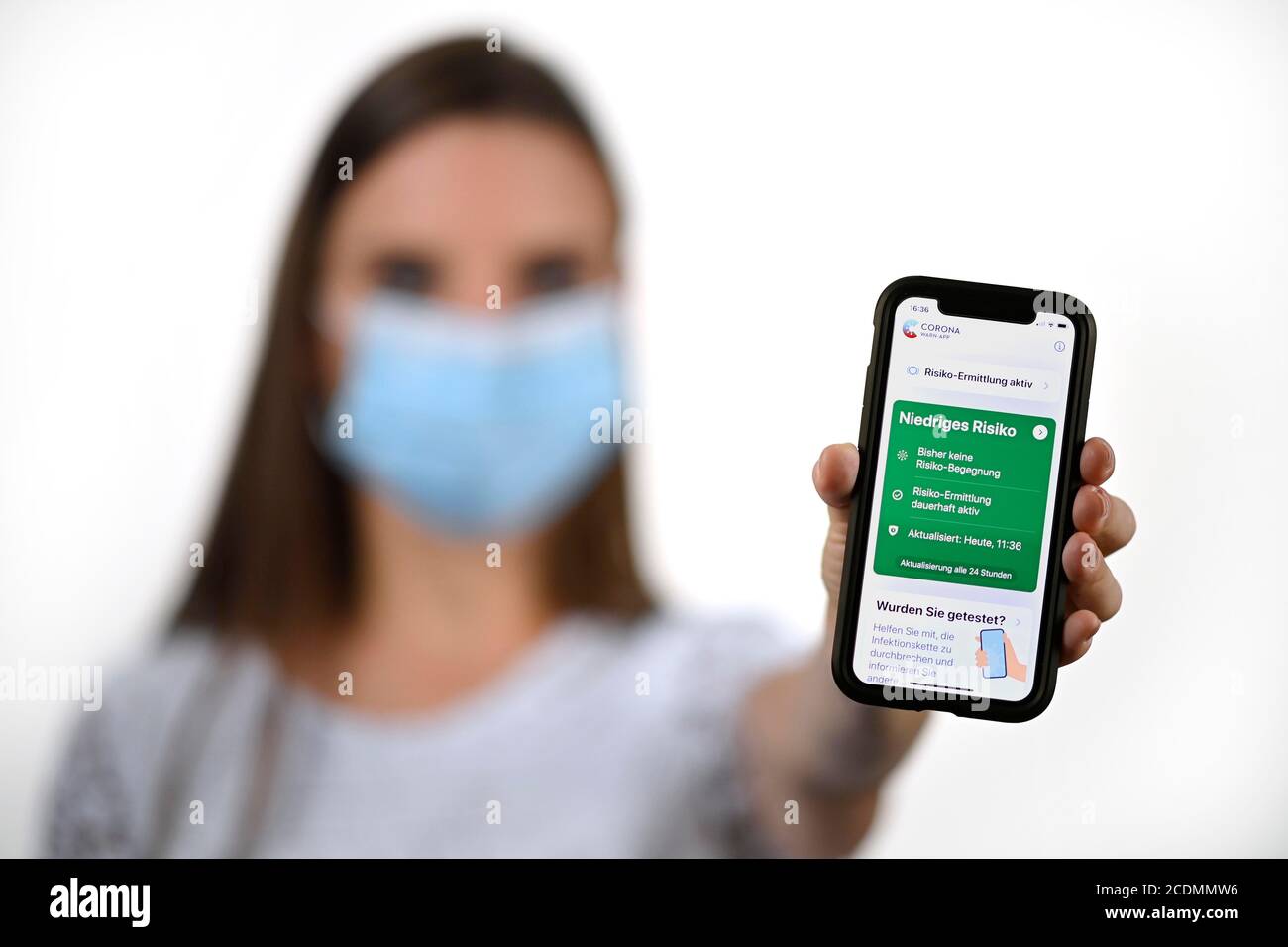 Femme avec masque de visage, montre smartphone avec Corona warn-APP dans la zone verte, crise de Corona, Bade-Wurtemberg, Allemagne Banque D'Images