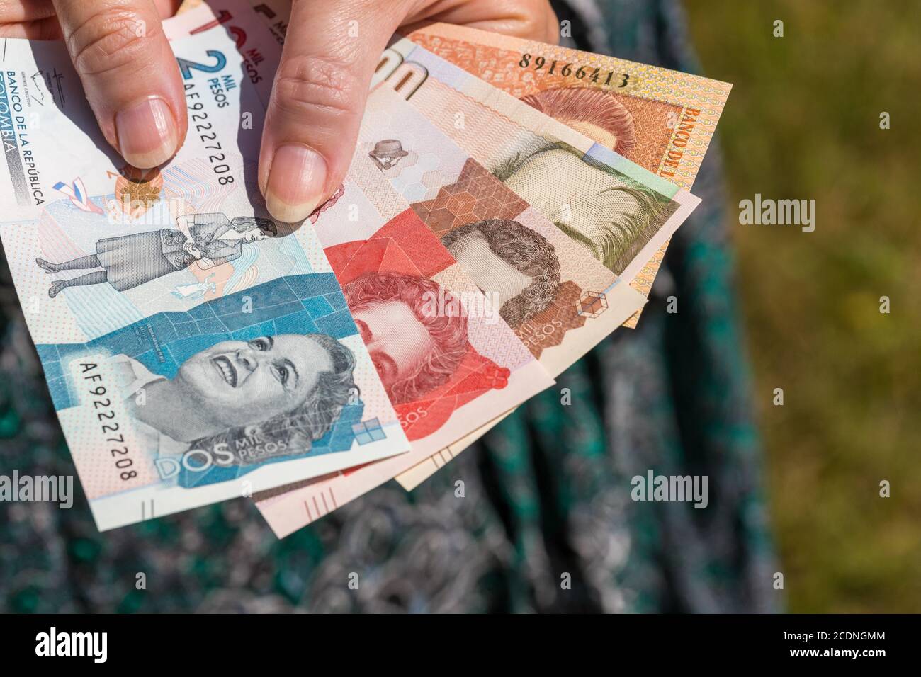 Une femme tient des pesos colombiens dans sa main. Mains sur le fond de la robe. Crise économique Banque D'Images