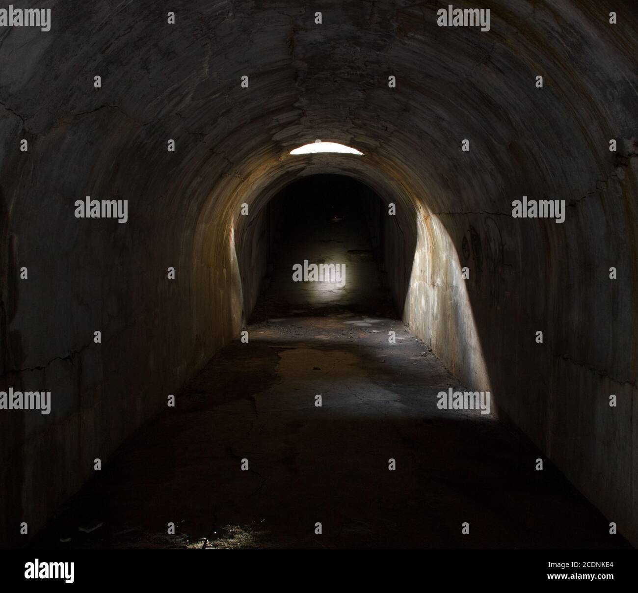 Un couloir souterrain s'étendant sur la distance, éclairé par une trappe dans le plafond. Banque D'Images