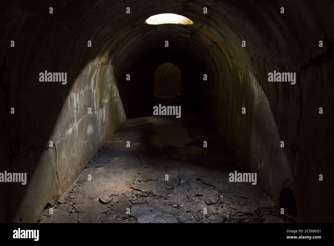 Un couloir souterrain s'étendant sur la distance, éclairé par une trappe dans le plafond. Banque D'Images