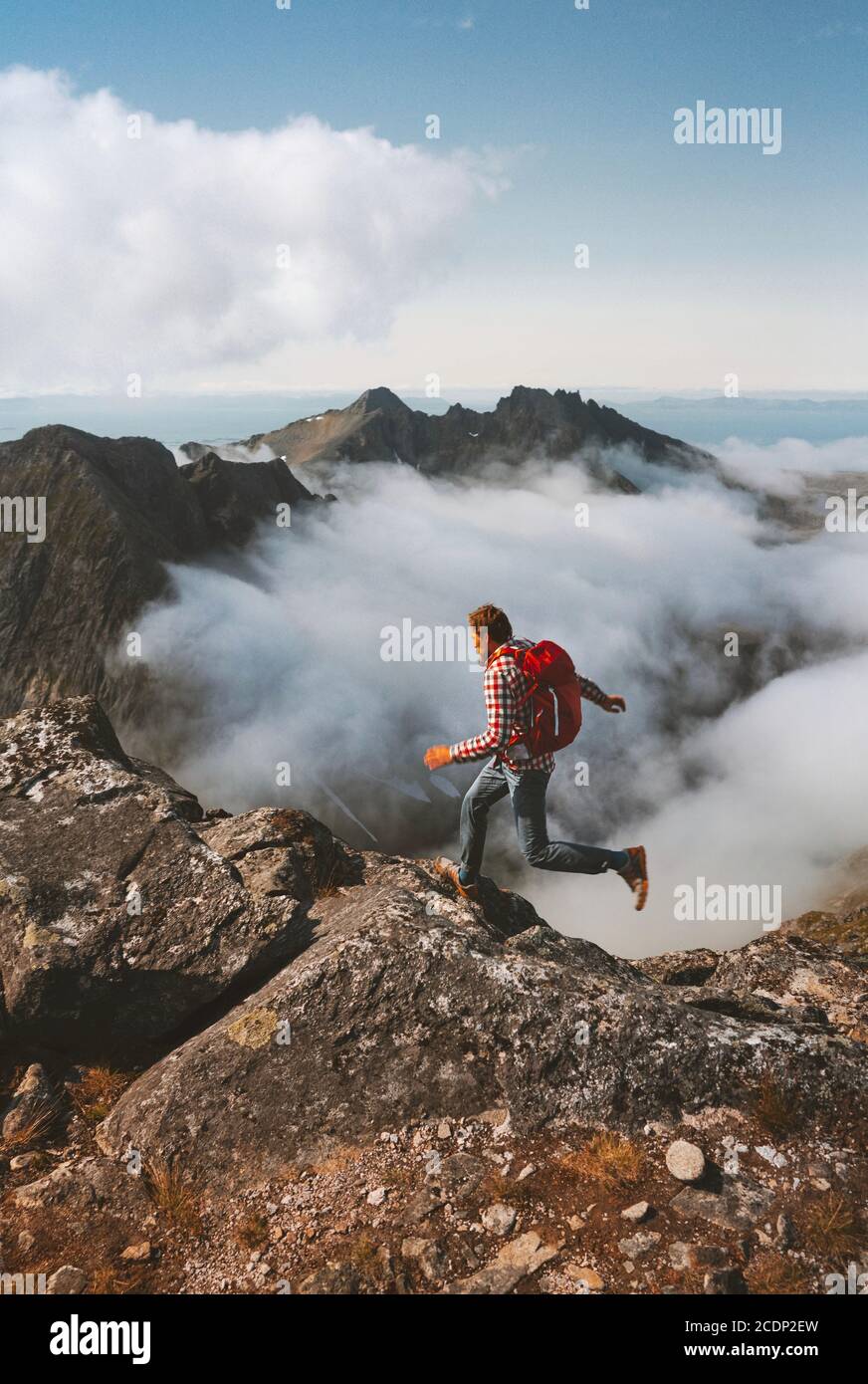 Sentier homme en montagne sur une falaise au-dessus des nuages en solo Voyage randonnées activités activités vacances en plein air en Norvège un mode de vie sain Banque D'Images