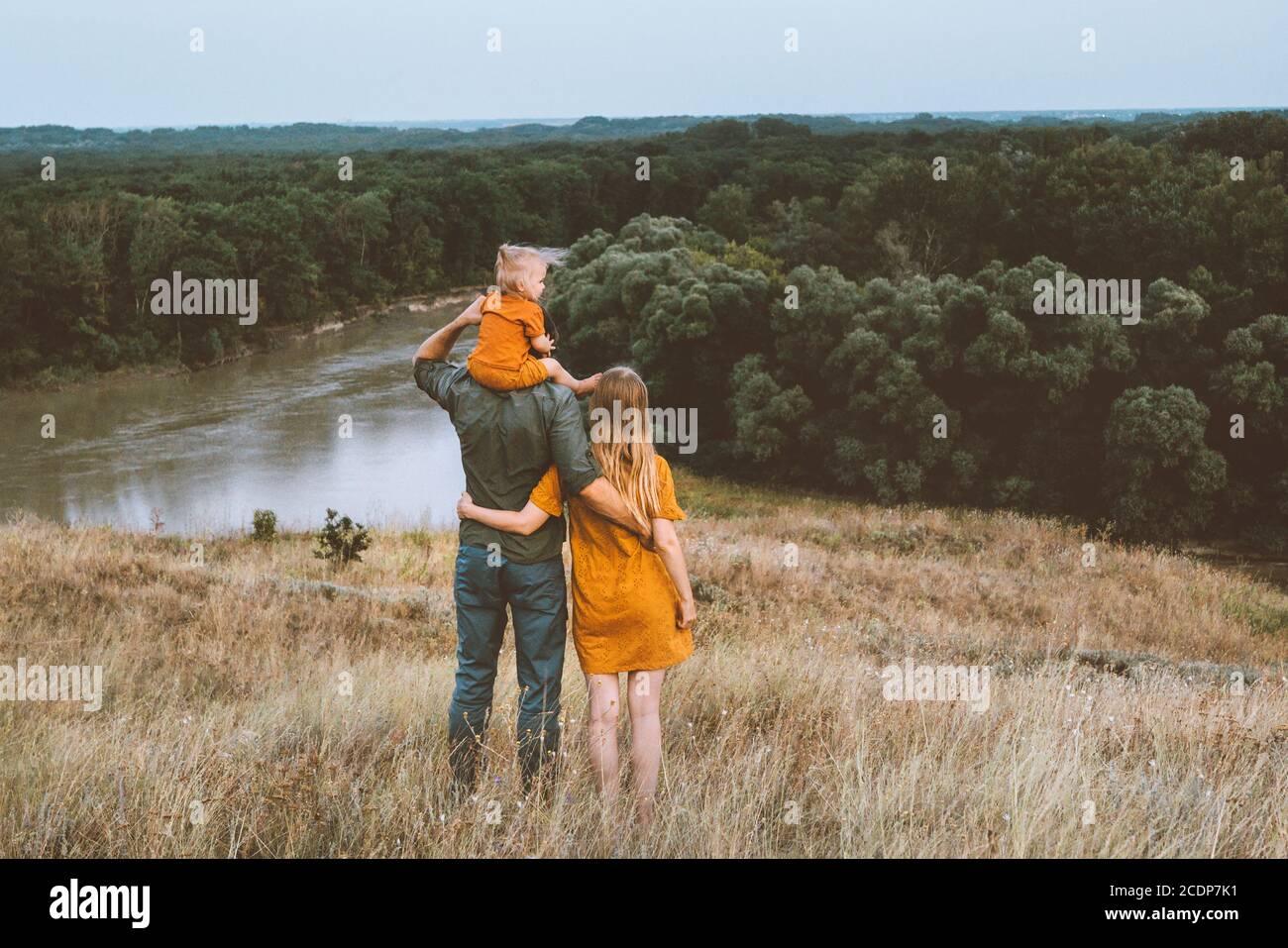 Parents de famille mère et père avec bébé assis sur les épaules profiter de la vue sur la rivière et la forêt en plein air saines vacances de style de vie Banque D'Images