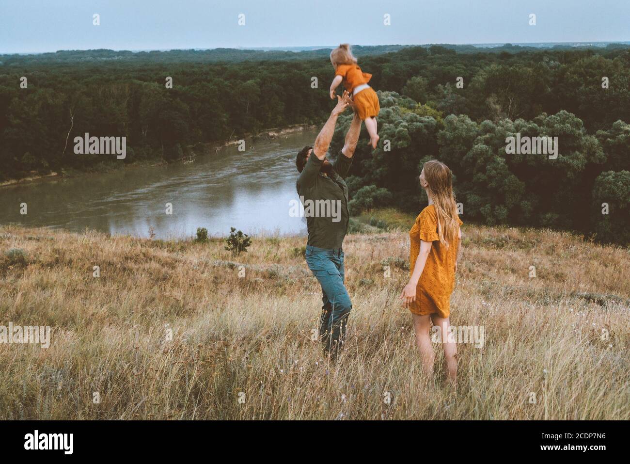 Père de famille et mère avec enfant jouant avec les parents en plein air bébé ayant plaisir actif sain style de vie heureux émotions rivière et paysage forestier Banque D'Images