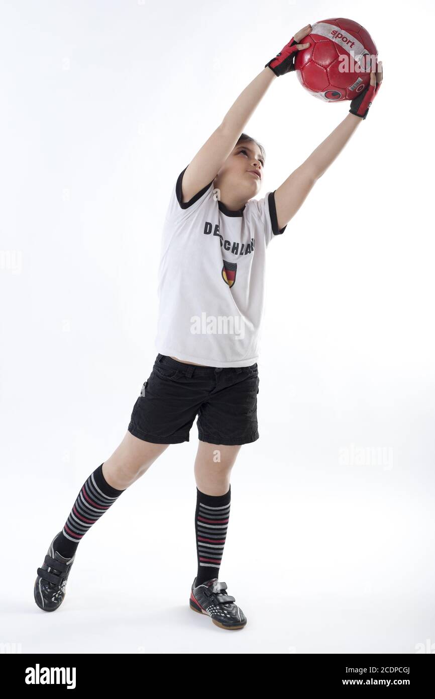 Jeune fille en vêtements de football avec maillot de l'Allemagne tenant un football Banque D'Images