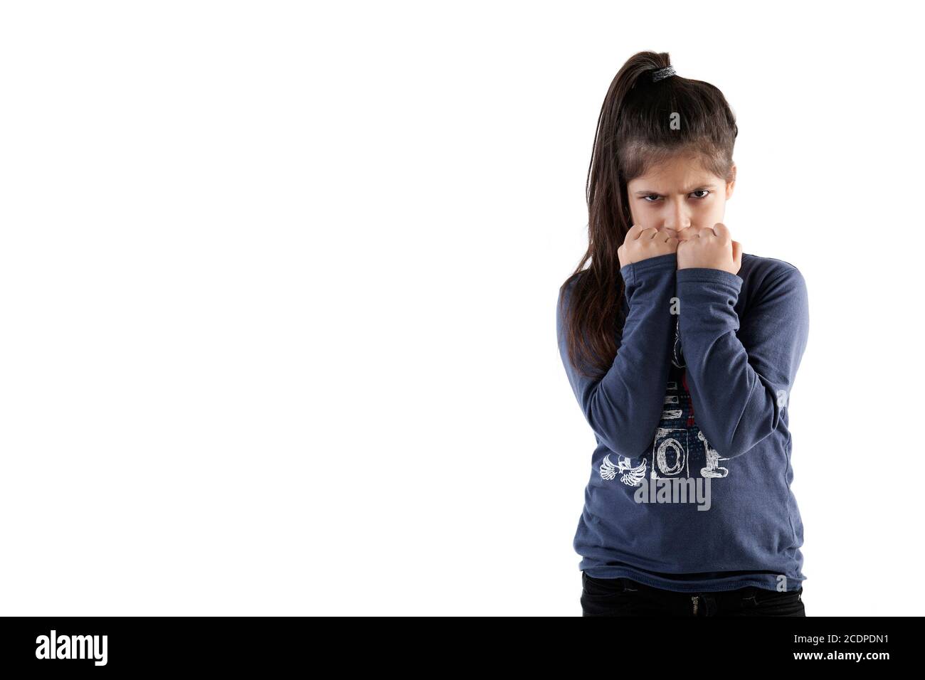 Jeune fille grimly-regardant avec ses mains avant son visage Banque D'Images