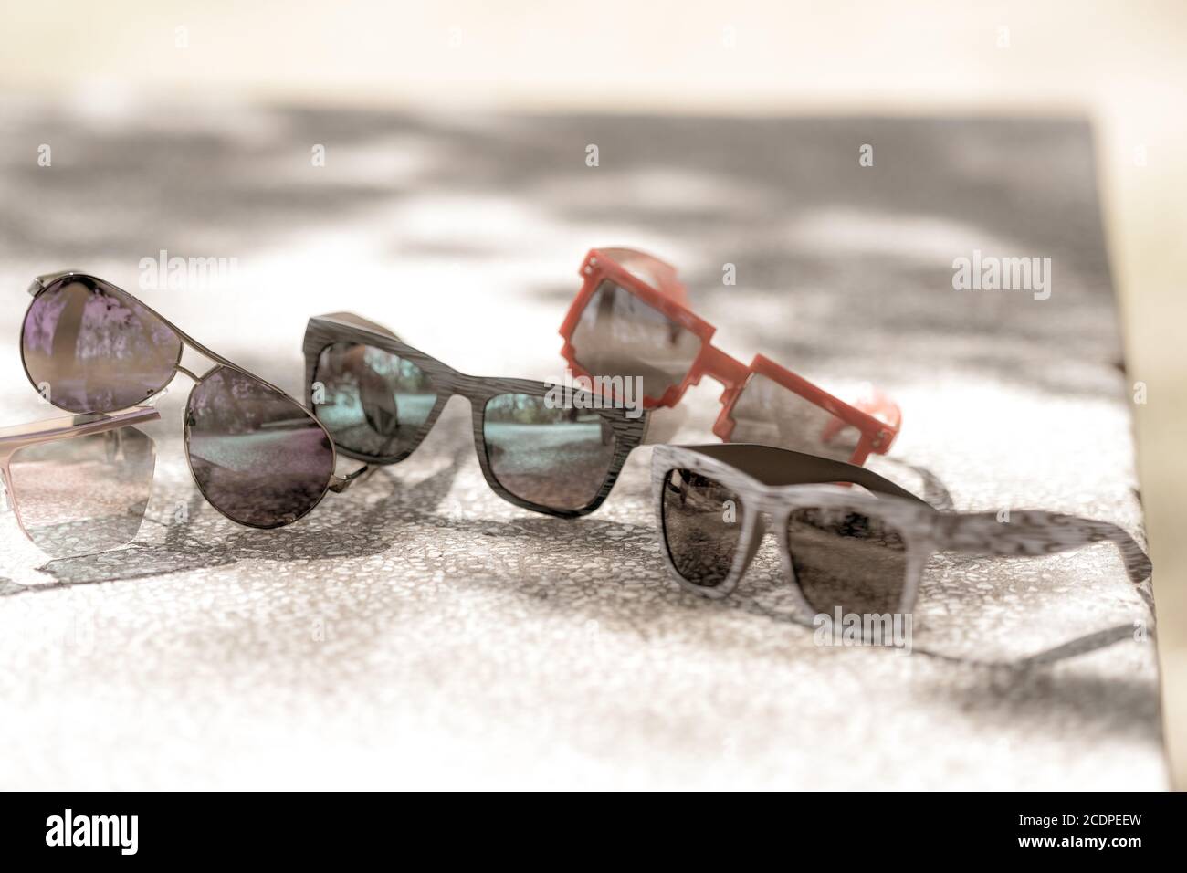 Collection de plusieurs modèles de lunettes de soleil pour hommes et femmes restent sur une table par temps ensoleillé. Mise au point sélective Banque D'Images